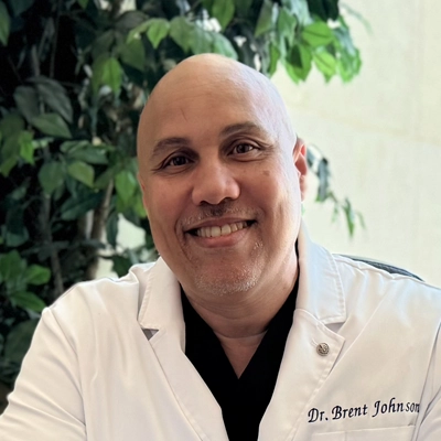 Dr. Brent Johnson smiling in a white coat.