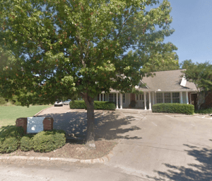 The Cleburne office from the street with a driveway leading up to the building